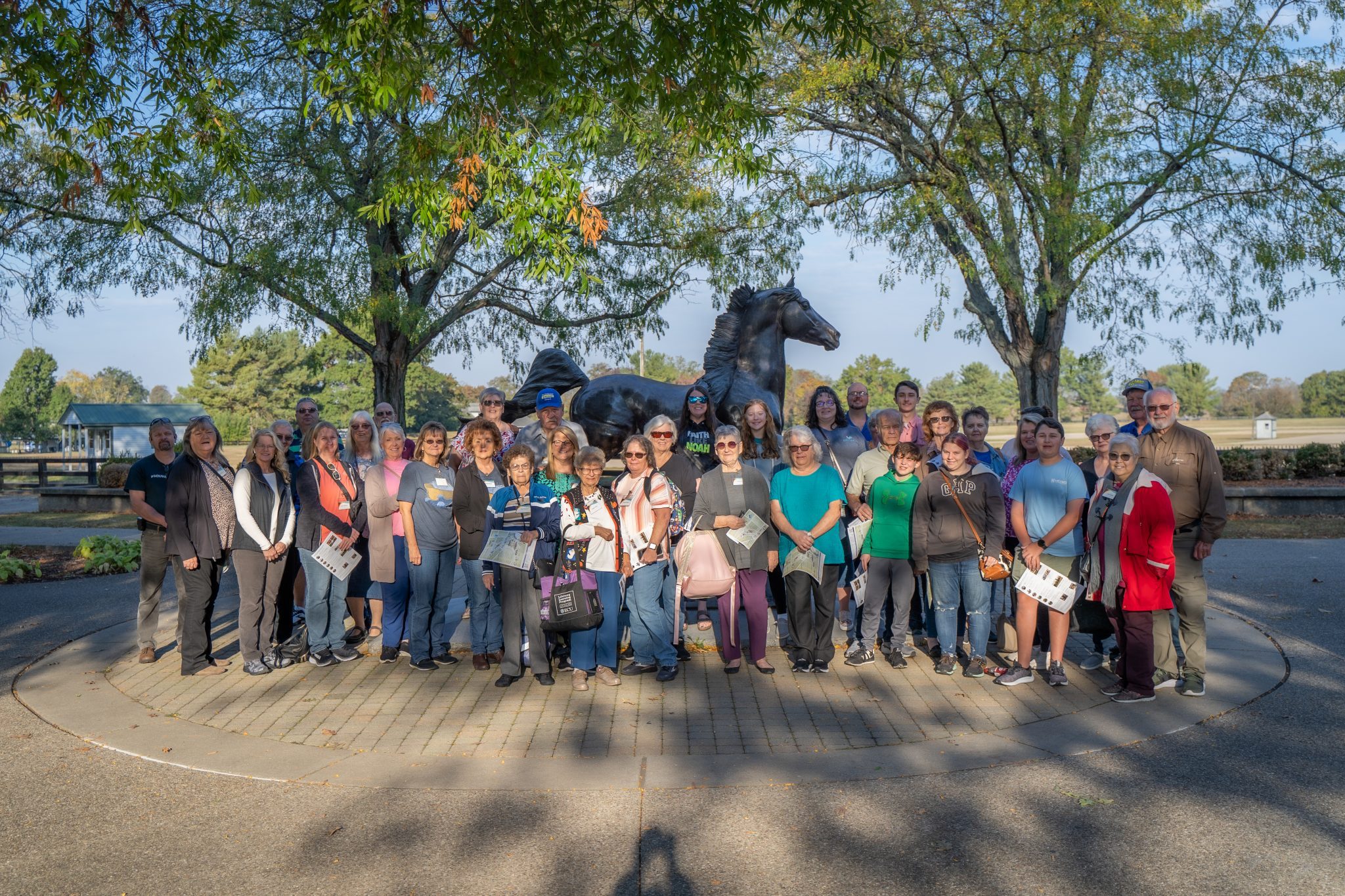 Group of people standing in from of Morgan Horse Statue